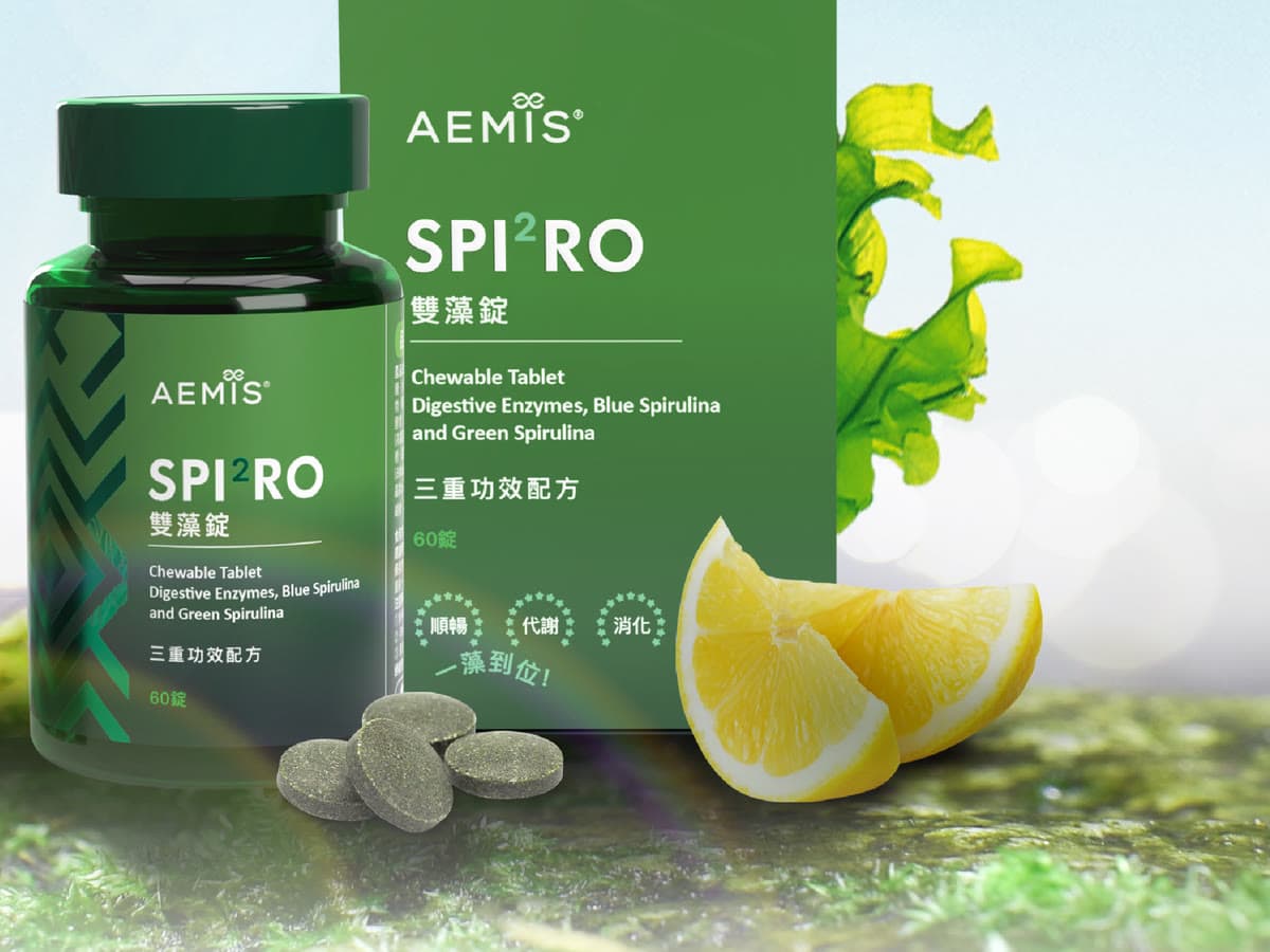 Botol dan kotak SPIRO Tablet Dua Alga, di depannya tiga tablet kunyah dan dua potong lemon